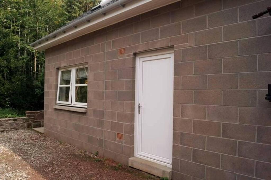 a white door on the side of a brick building at Self-contained 1-Bed Apartment in Kirriemuir in Kirriemuir