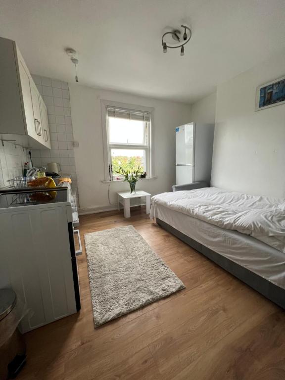 a bedroom with a bed and a kitchen with a window at Islington Apartments in London
