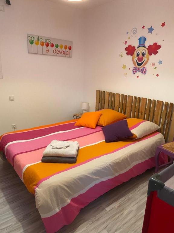 a bedroom with a large bed with a colorful blanket at Chambre les Hortensias in Challans