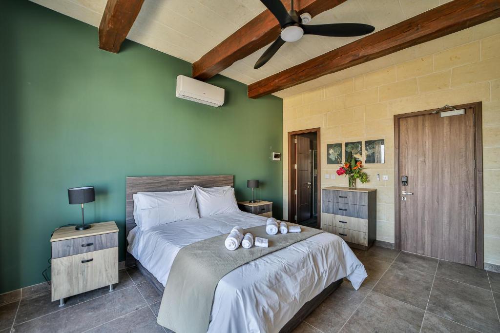 a bedroom with a bed and a ceiling fan at 49 Sunrise Lodge in Għajnsielem