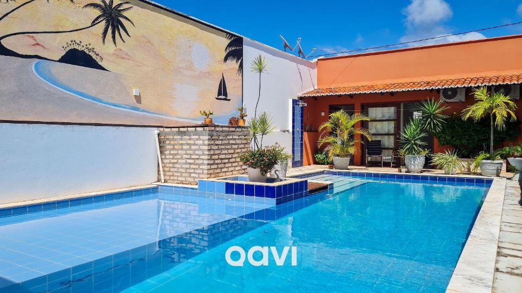 een zwembad voor een huis met muurschildering bij Qavi - Casa Tropical #ParaísoDoBrasil in Touros
