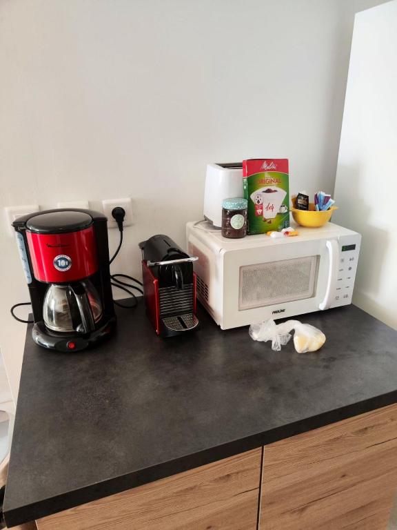 a kitchen counter with a microwave and a coffee maker at Maison de 2 chambres avec vue sur la mer jardin clos et wifi a Sete in Sète