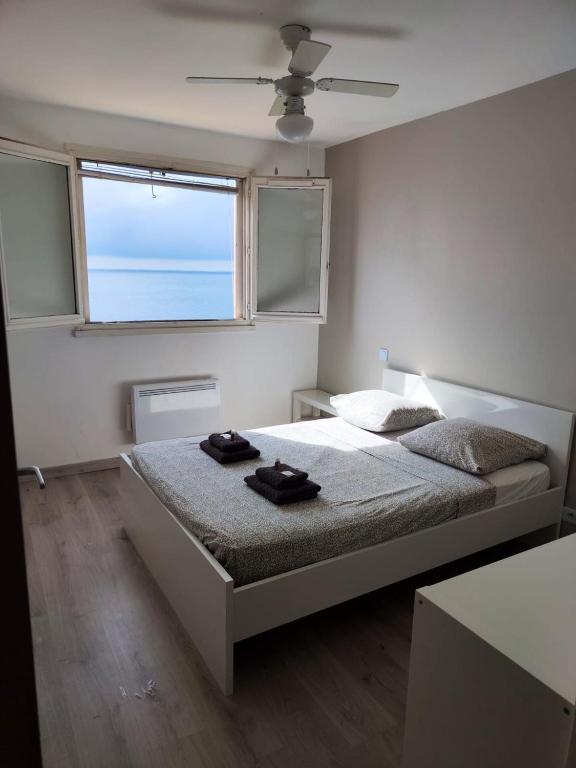 a bedroom with a bed with two black towels on it at Maison de 2 chambres avec vue sur la mer jardin clos et wifi a Sete in Sète