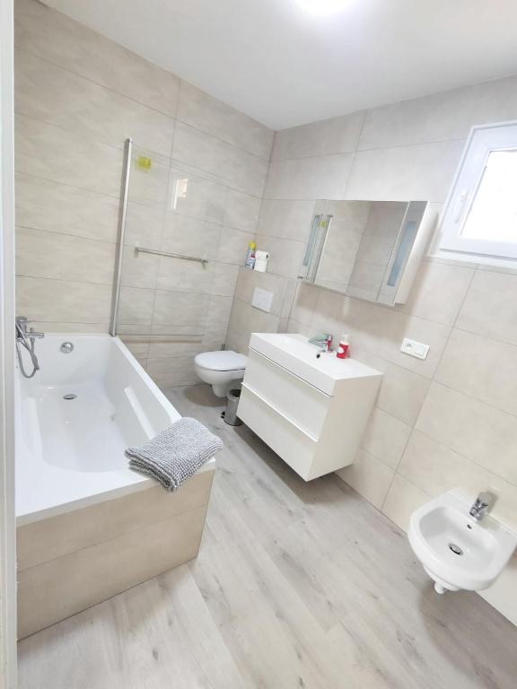 a bathroom with a tub and a toilet and a sink at Maison de 2 chambres avec vue sur la mer jardin clos et wifi a Sete in Sète