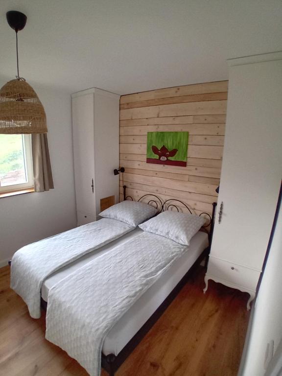 a bedroom with a large bed with a wooden headboard at Ferienhaus am Kuhstall in Bad Münstereifel