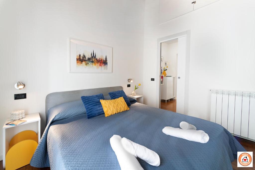 a bedroom with a blue bed with white shoes on it at Nido Milanese - Bocconi, Navigli, Duomo in Milan
