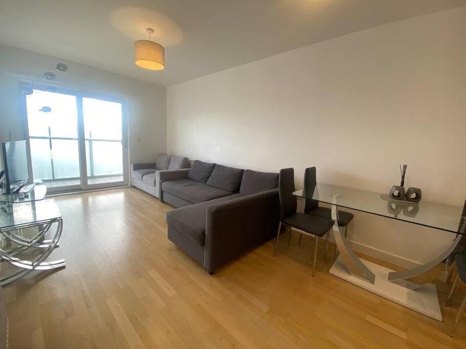 a living room with a couch and a glass table at Stunning 2 Bedroom Apartment in Croydon