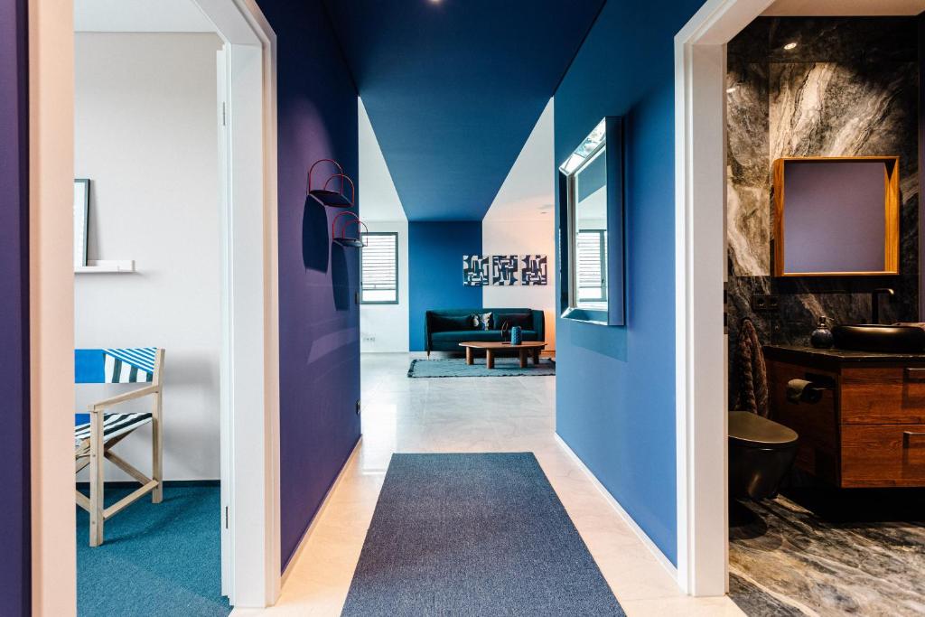 un couloir aux murs bleus et un salon dans l'établissement Exklusive Design Appartement Deep Blue Neubau, à Pfungstadt