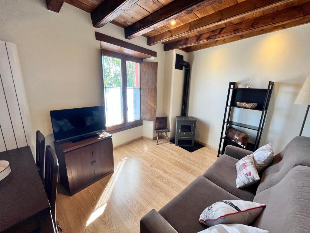 un soggiorno con divano e TV a schermo piatto di Casa Bernat Apartament a Puigcerdà