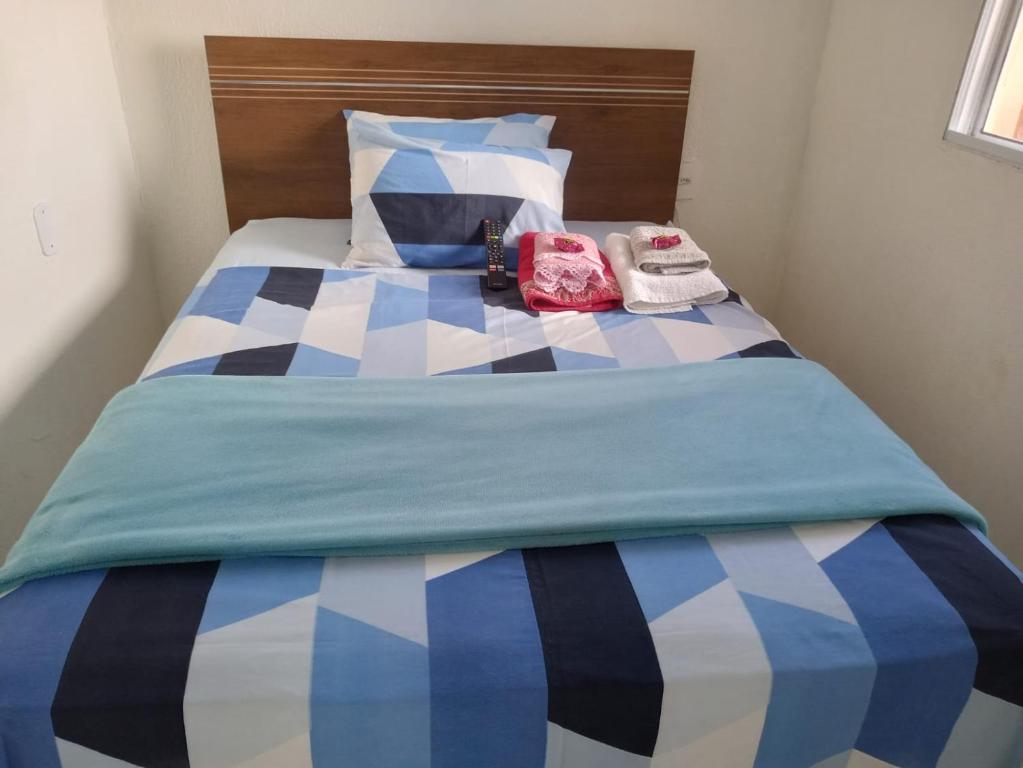 uma cama com colcha azul e branco xadrez em Cozy House Booking Indaiatuba em Indaiatuba