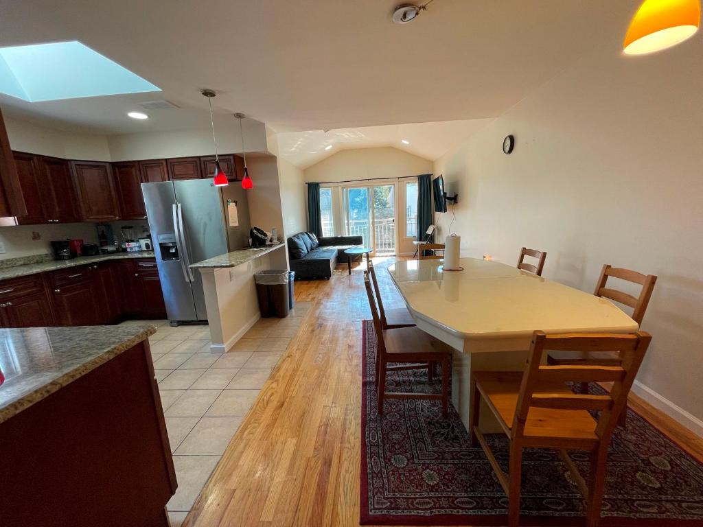 uma cozinha e sala de estar com mesa e cadeiras em Business & Family Friendly Balcony Jacuzzi Free Park em Jersey City