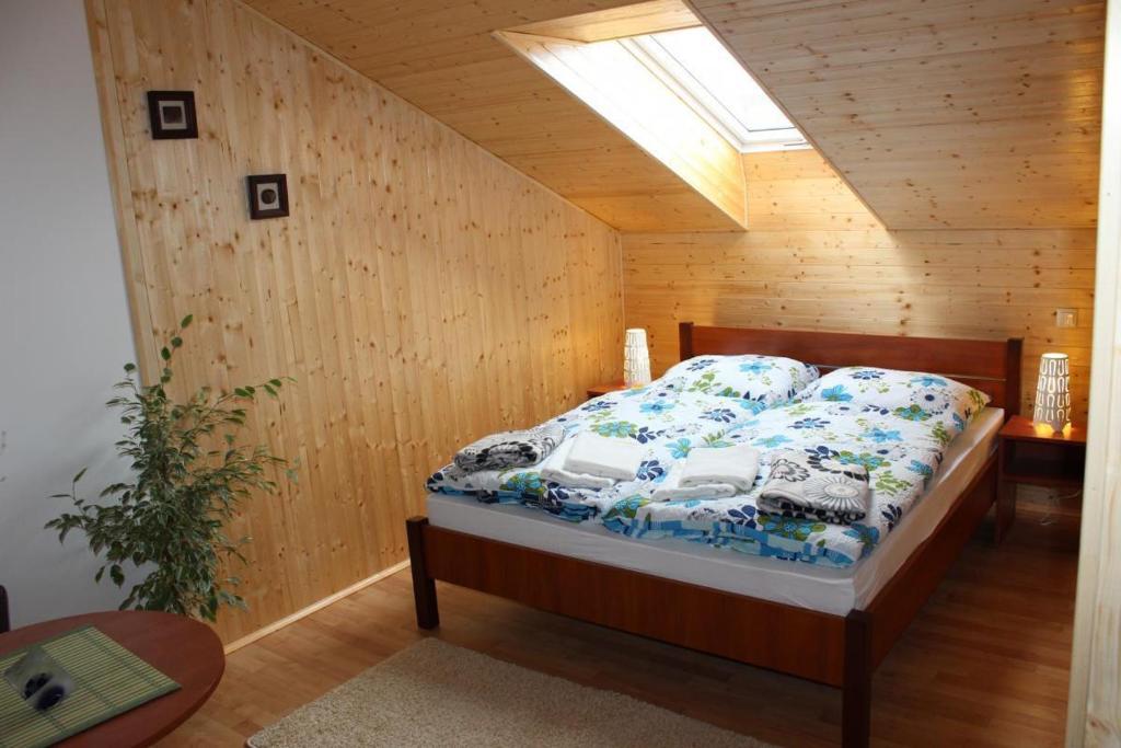 sypialnia z łóżkiem w drewnianej ścianie w obiekcie Studio Glass Vysočina w mieście Škrdlovice
