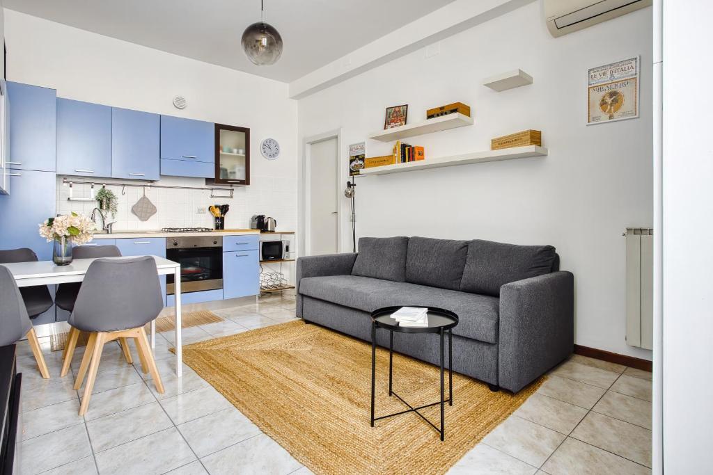 een woonkamer met een bank en een tafel bij Casa Azzurra - Città Studi in Milaan