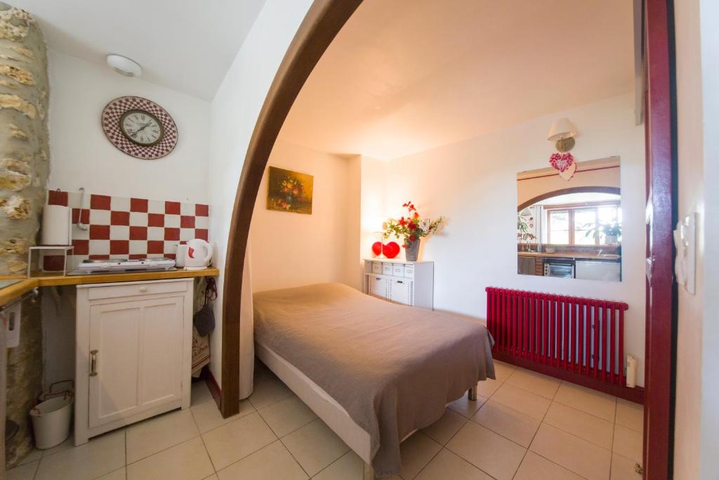 a small bedroom with a bed and a kitchen at Le charmant in Bussy-Saint-Georges