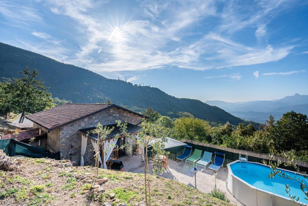 un complexe avec une piscine et des montagnes en arrière-plan dans l'établissement Agriturismo La Vecchia Scuola, à Villa Collemandina