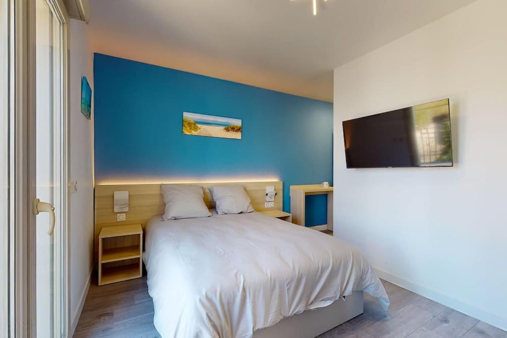 a bedroom with a large bed with a blue wall at 11.Studio#Creteil#Loft#Cinéma in Créteil