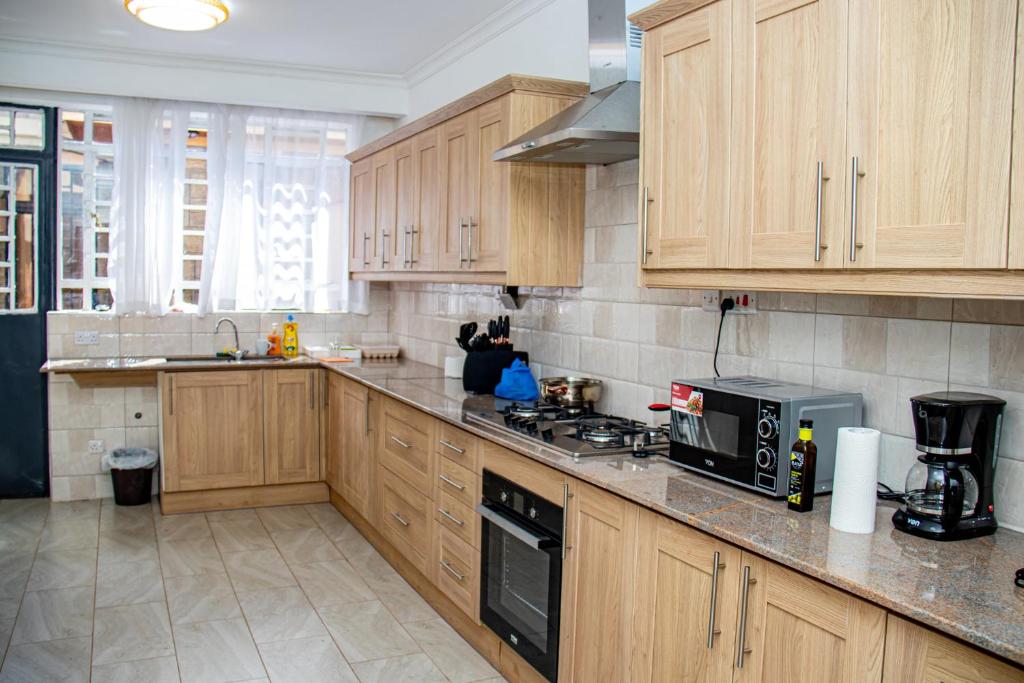 a kitchen with wooden cabinets and a stove top oven at Kathy's Two Bedrooms in Nairobi