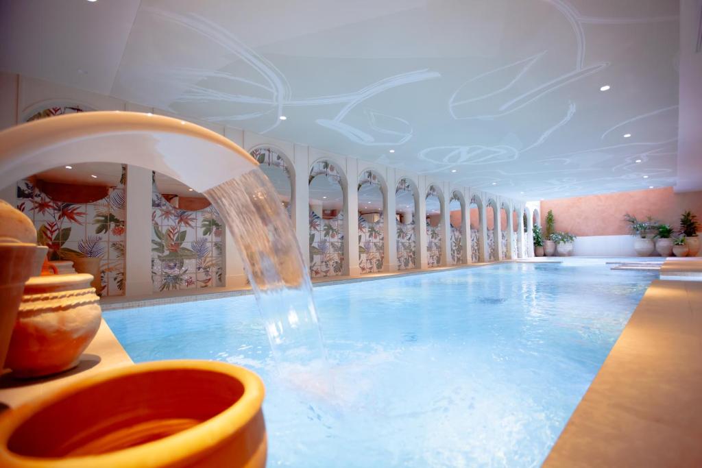 a large swimming pool with a water fountain at Bloom House Hôtel & SPA in Paris