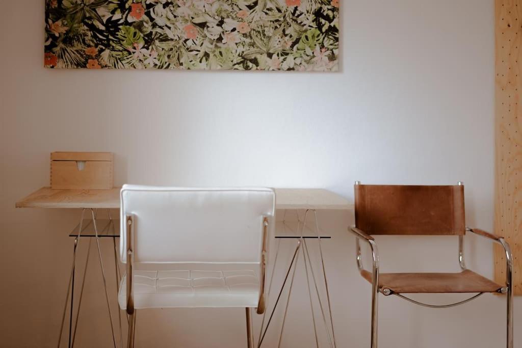 un escritorio con 2 sillas y un cuadro en la pared en Prostorný byt u centra Zlína s atmosférou venkova en Zlín