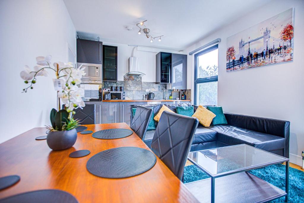 uma cozinha e sala de estar com uma mesa e um sofá em Peckham Plaza em Londres