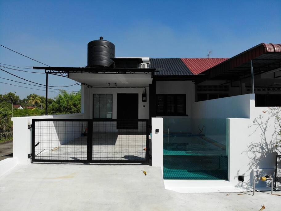 una casa con una puerta delante de ella en Zen Retreat Glass Pool Villa, en Kamunting