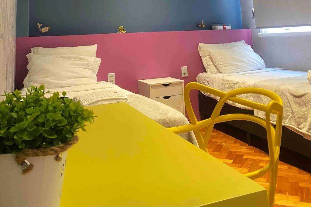 una mesa amarilla en una habitación con 2 camas en Carioca Beach Retreat, en Río de Janeiro