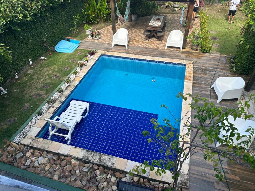 een uitzicht op een zwembad met 2 stoelen en een tafel bij Casa Praia de Gaibu in Cabo de Santo Agostinho