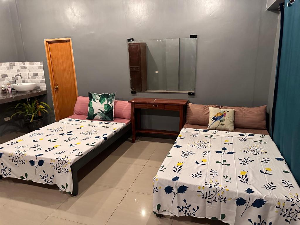 a room with two beds and a sink and a mirror at Limewood Residences- Bago City good for 4 in Bago