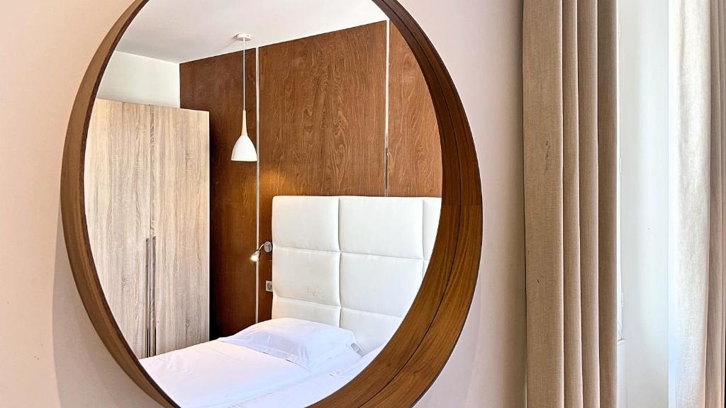ein Spiegel hängt an einer Wand in einem Zimmer in der Unterkunft Hotel Le Florian in Cannes