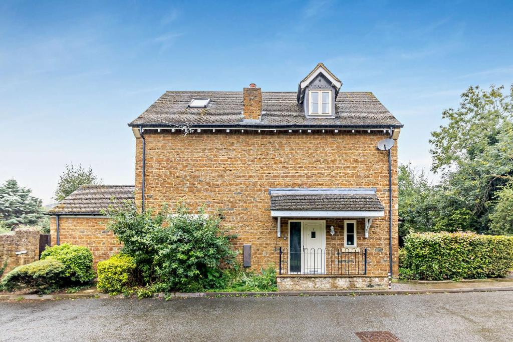 a brick house with a window and a roof at Tall Trees. Luxury North Cotswold cottage in Banbury