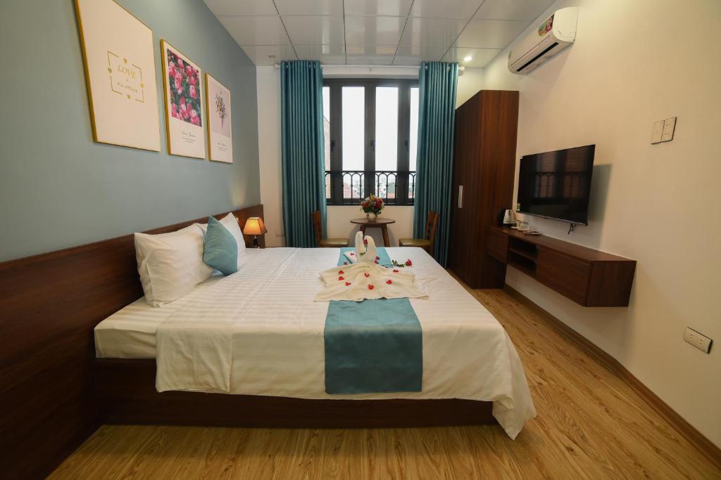 um quarto de hotel com uma cama com televisão e uma cama sidx sidx em AnAn Homestay Huế em Hue