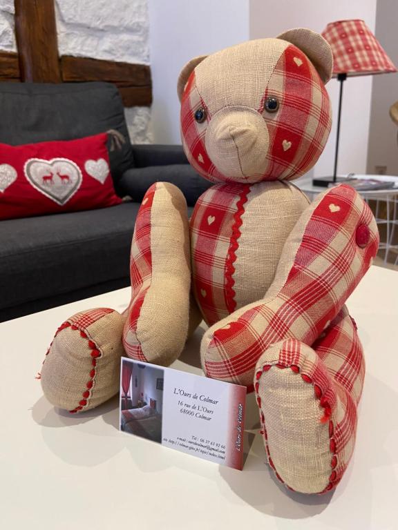 un ours en peluche assis au-dessus d'une table dans l'établissement L'Ours de Colmar - Appartements en centre ville, à Colmar