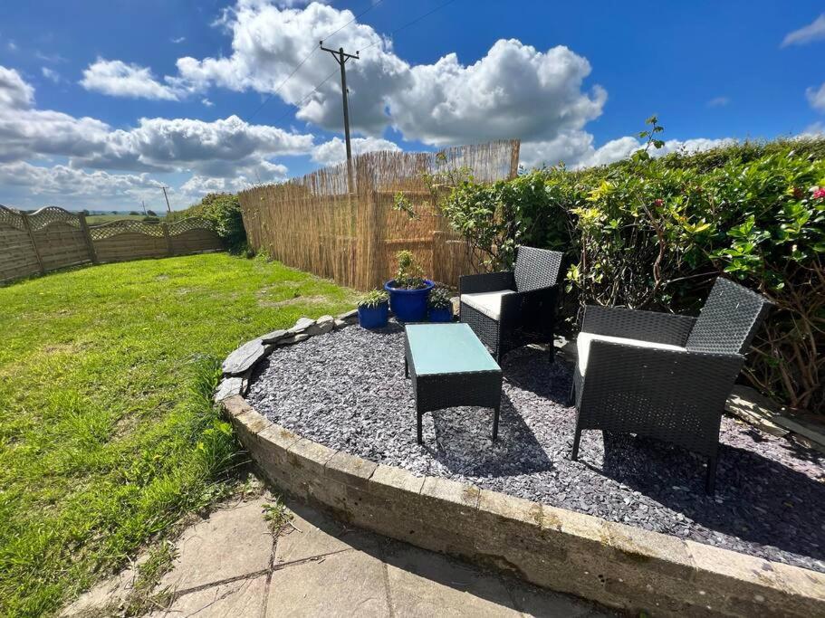 a patio with chairs and a table in a yard at 2 bedroom holiday home in the heart of west wales in St Clears