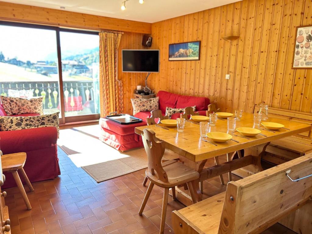 - une salle à manger avec une table en bois et un canapé dans l'établissement Appartement spacieux aux Gets, pied des pistes, balcon sud-ouest, 2 chambres, coin cabine, garage, WiFi - FR-1-623-81, aux Gets