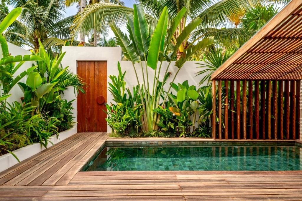 a swimming pool in front of a house with a wooden deck at Manao Villas in General Luna