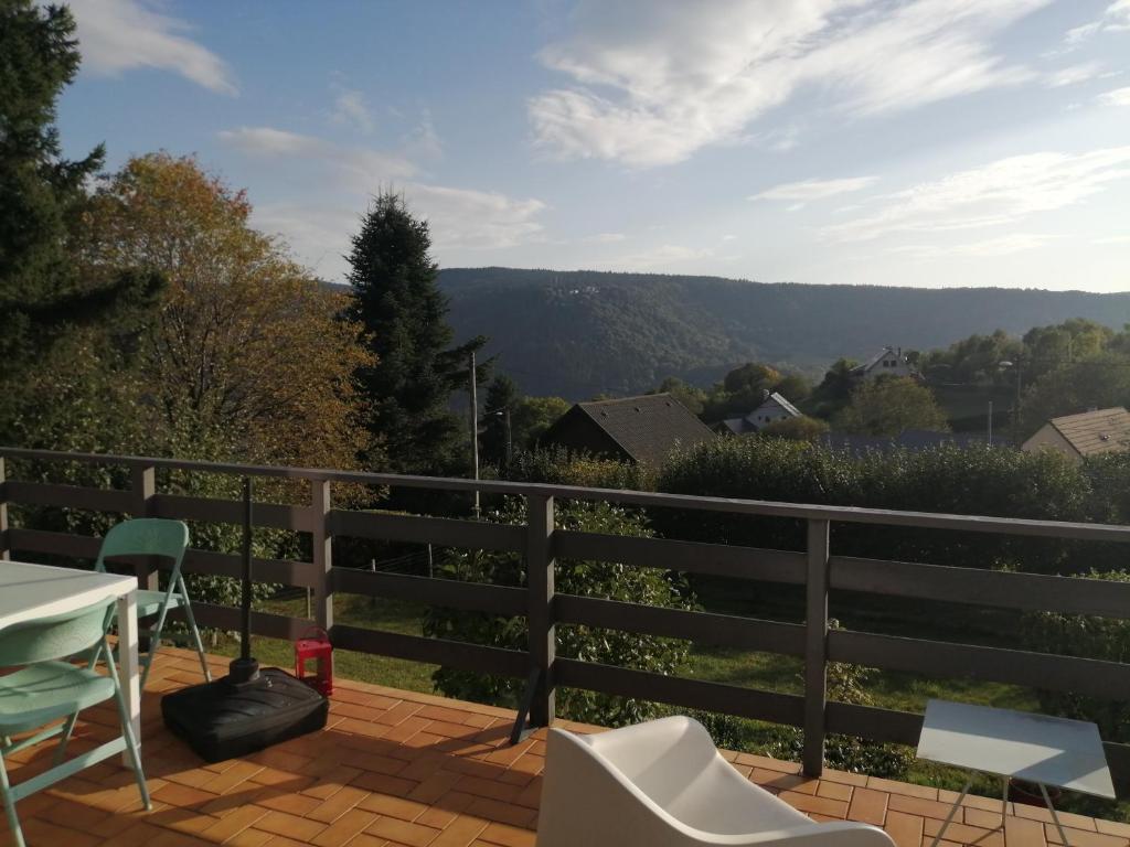 a balcony with a table and chairs and a view at Chalet Dionysos in Murat-le-Quaire