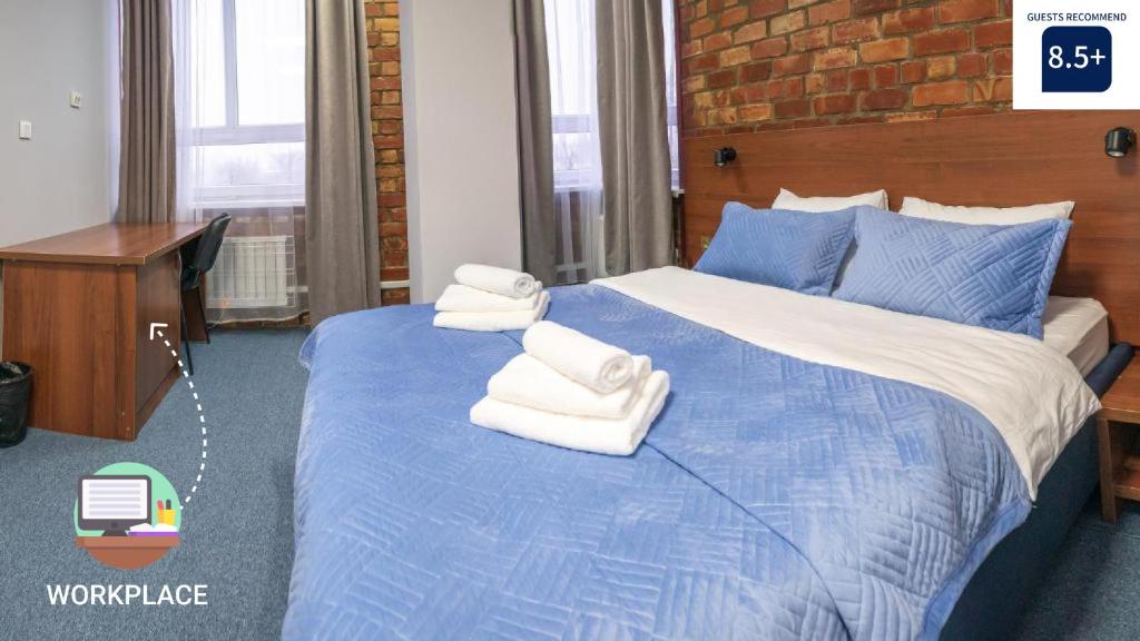 um quarto com uma cama azul com toalhas em Eva At Home - Bishkek em Bishkek