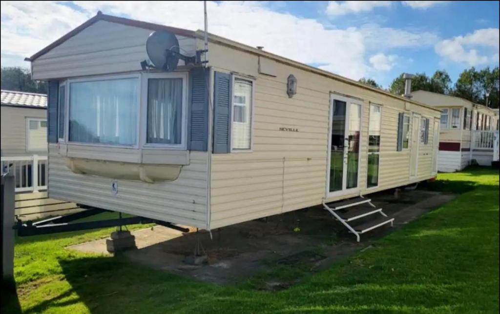a mobile home is parked in a yard at 2 Bedroom Caravan With Sea Views in Eastchurch