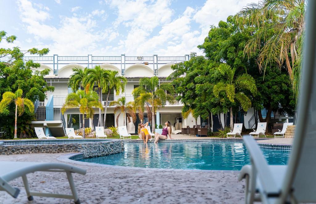 two people sitting in the swimming pool of a hotel at Solace by the Sea in Ponce