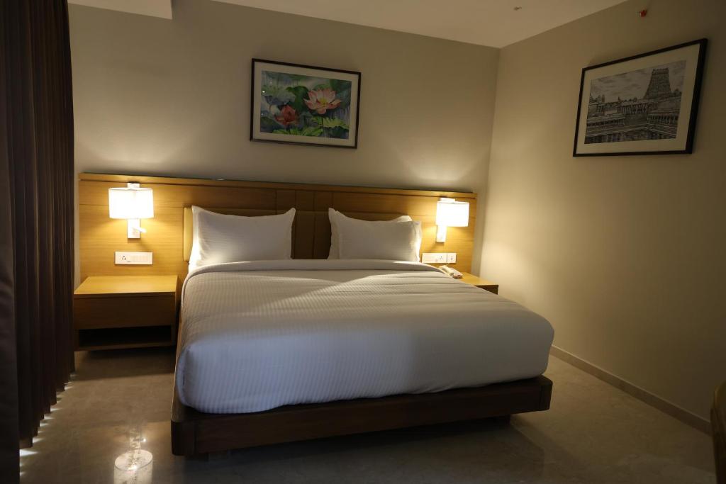 a bedroom with a large bed with two lamps at M Central in Chennai