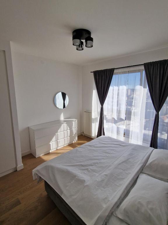 a bedroom with a large bed and a window at Grey - Beograd na vodi -Belgrade waterfront in Sajmište