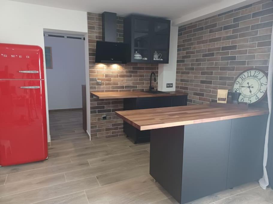 a kitchen with a red refrigerator and a brick wall at Apartamento El Maset in Tárrega