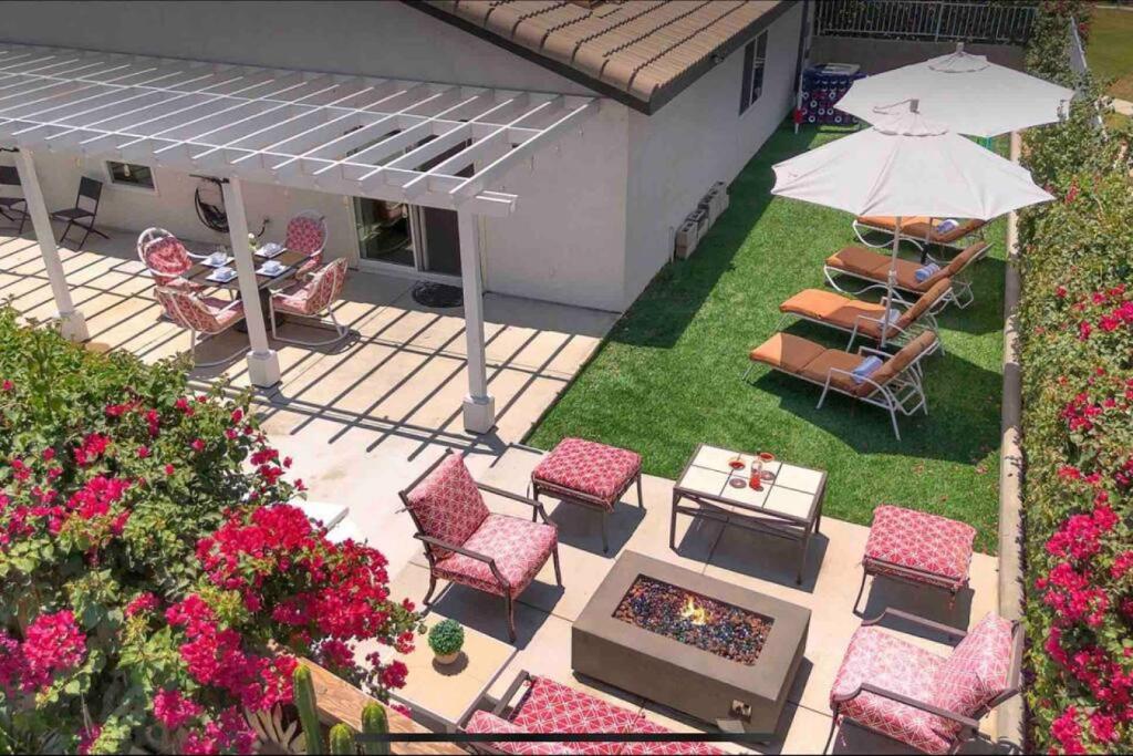 Elle offre une vue sur la terrasse dotée de chaises et d'un parasol. dans l'établissement The Coachella Gem weekly discounts, à Coachella