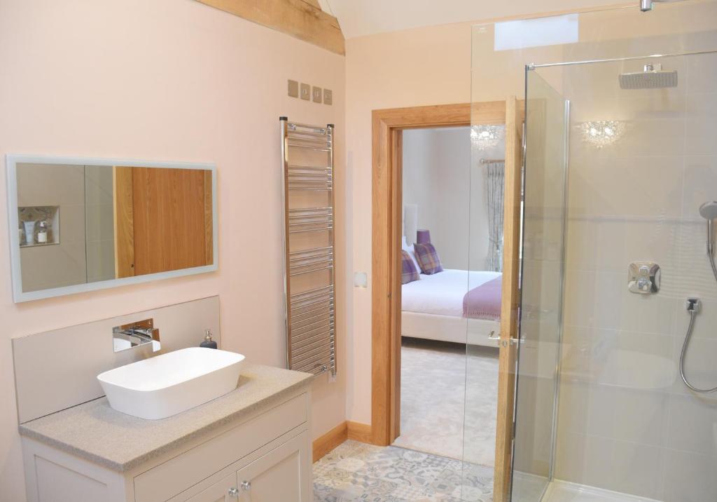 a bathroom with a sink and a shower at Lily Rose Cottage in Broadway