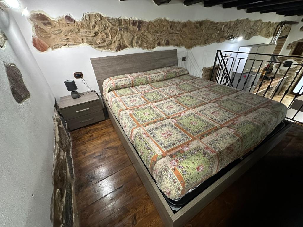 sypialnia z łóżkiem z kołdrą w obiekcie Casa Vacanza al Centro di Iglesias tra Mare e Miniere w mieście Iglesias