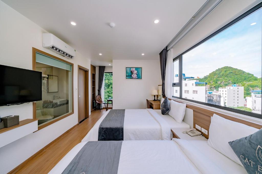 um quarto de hotel com uma grande janela e uma cama em CAT BA ECO HOTEL em Ilha de Cát Bà