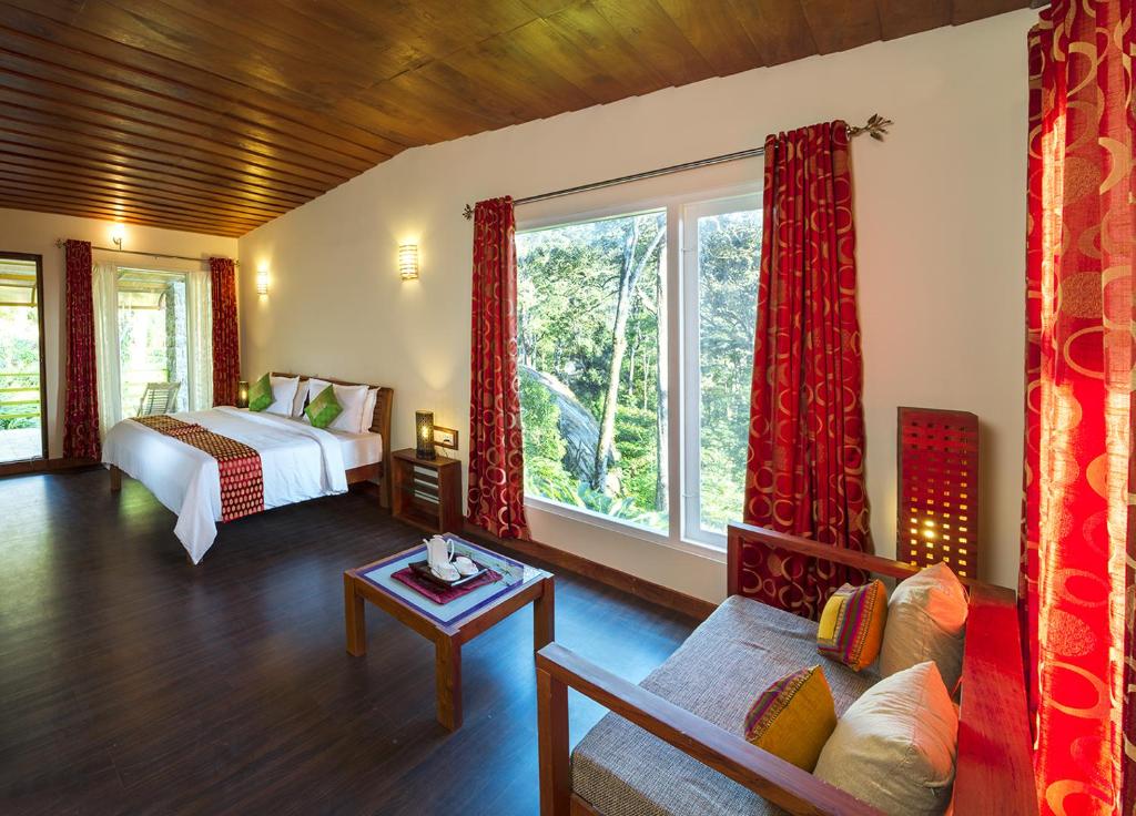 a bedroom with a bed and a large window at Neelakurunji Plantation Munnar in Chinnakanal