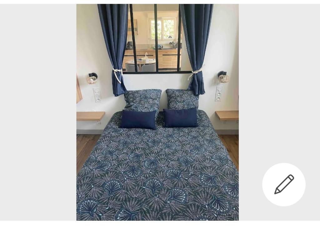 Pokój z łóżkiem z 2 niebieskimi poduszkami w obiekcie Anna w mieście Pléboulle