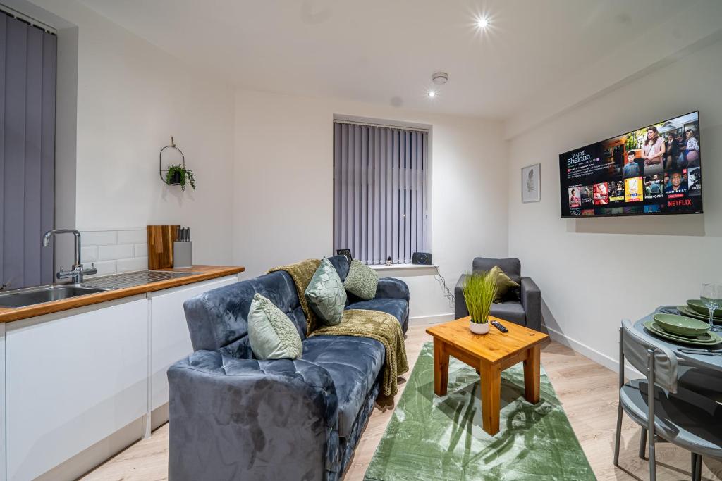 a living room with a blue couch and a table at 2-Bedroom Cozy Hideaway Close to Hollingworth Lake in Milnrow in Rochdale