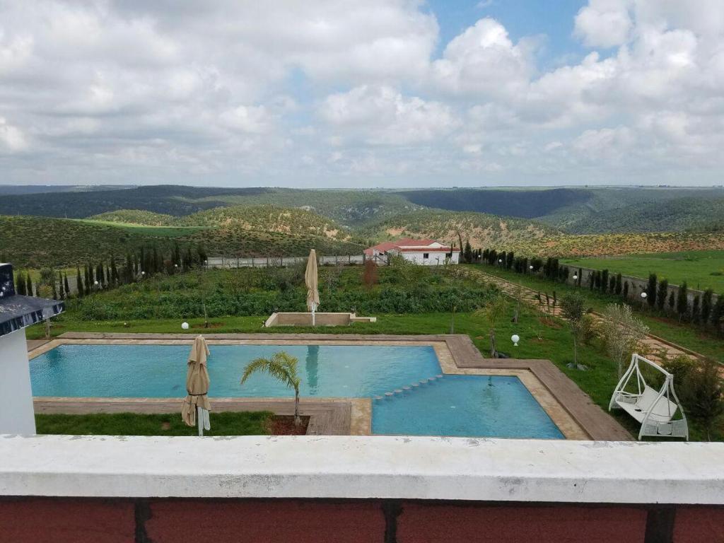een uitzicht vanaf het balkon van een resort met 2 zwembaden bij Maison Ain Lakssab in Ben Slimane